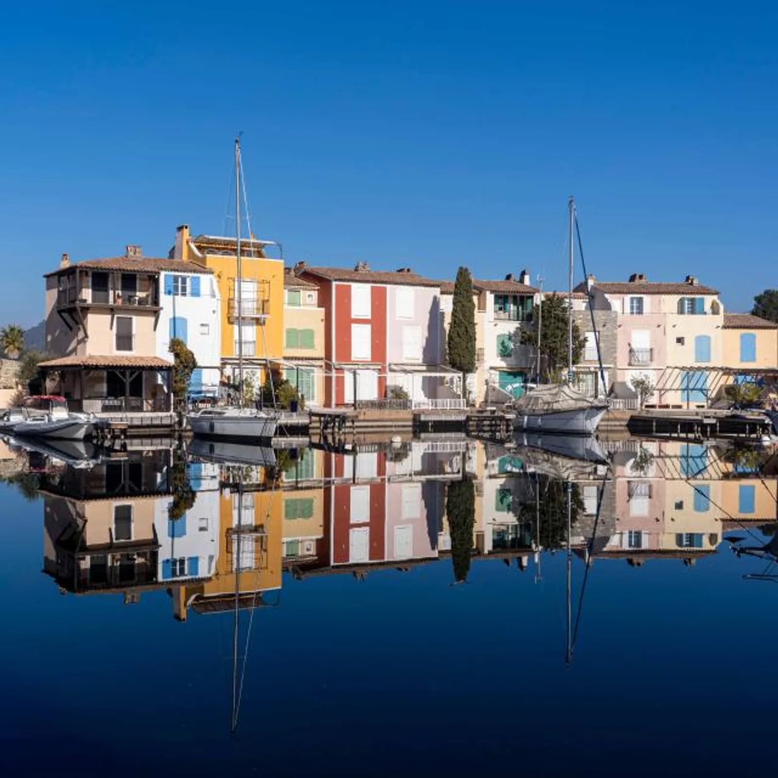 Maisons colorées de Port Grimaud reflétées dans le canal — la Venise provençale