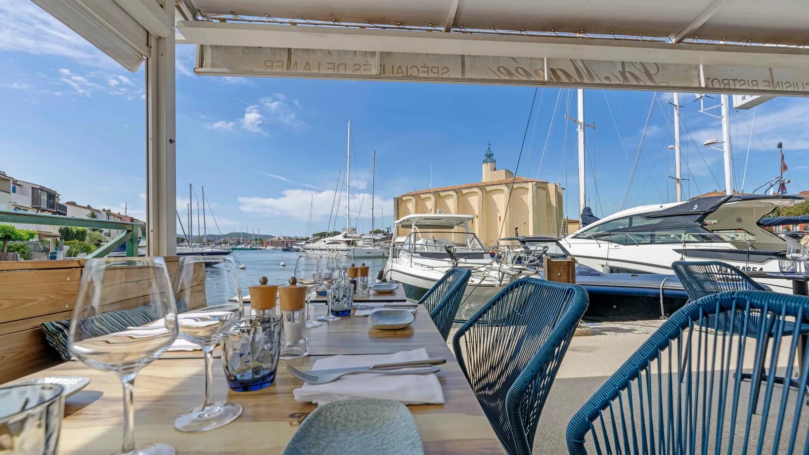 Vue depuis la terrasse du restaurant La Marée à Port Grimaud — bateaux du port et église Saint-François-d'Assise en arrière-plan